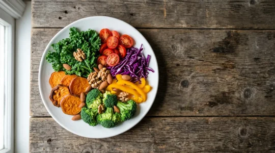 Assiette vue de dessus remplie d'aliments riches en vitamines et minéraux avec légumes colorés, fruits et noix