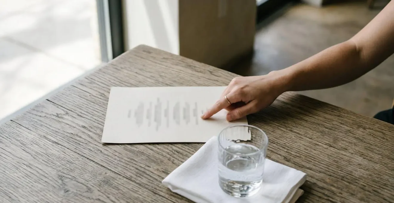 Vue en plongée d'un menu de restaurant avec une main qui pointe subtilement vers des options saines